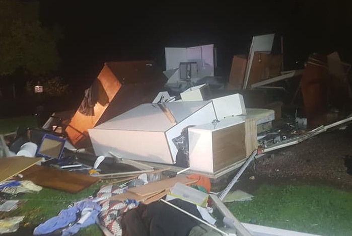 Household debris is scattered around as if the walls of the house are gone.