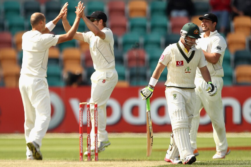 Phil Hughes trudges off with Kiwis celebrating in the background