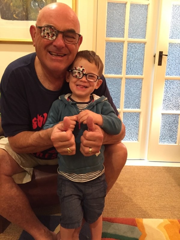 Hamish wears an eye patch as his father wears one too and gives a thumbs up.