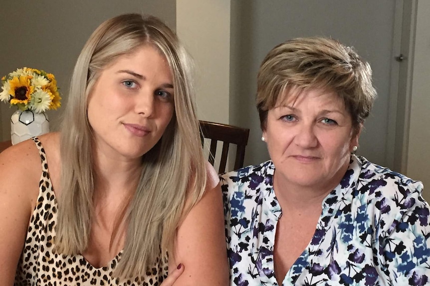 A young woman with long blonde hair and an older woman with short hair.