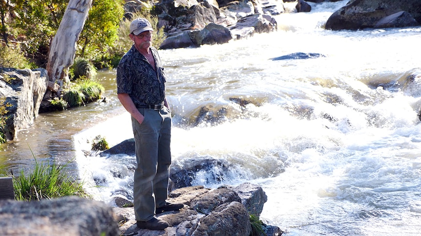 A picture of Jeffe Aronson standing on a rock in rapids on the Bundara River at Anglers Rest.