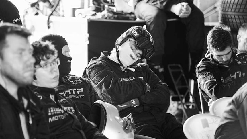Black and white photograph of race car drivers resting