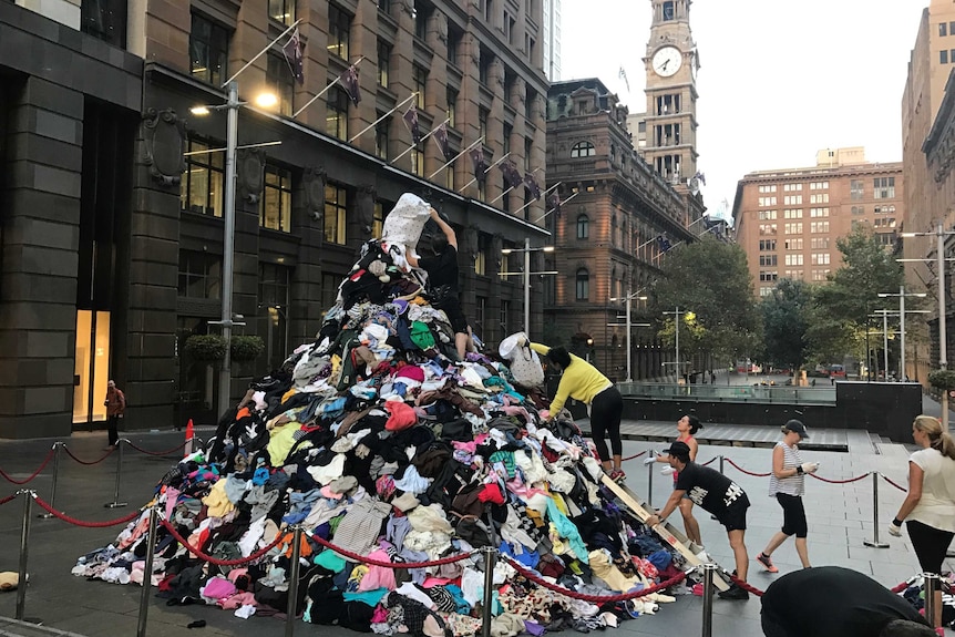 War on Waste production team building a pile of clothes in Martin Place, Sydney.
