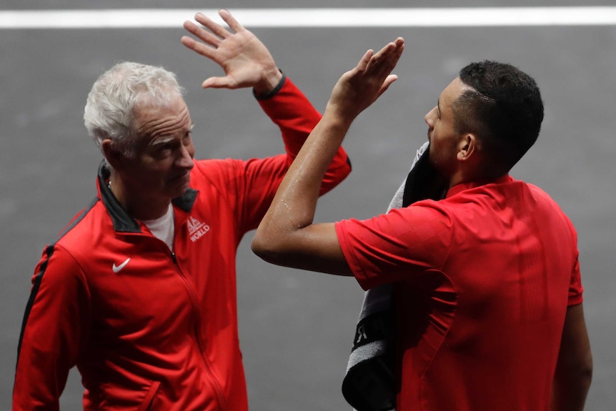 Team World's Nick Kyrgios high-fives captain John McEnroe during a singles match at the Laver Cup.