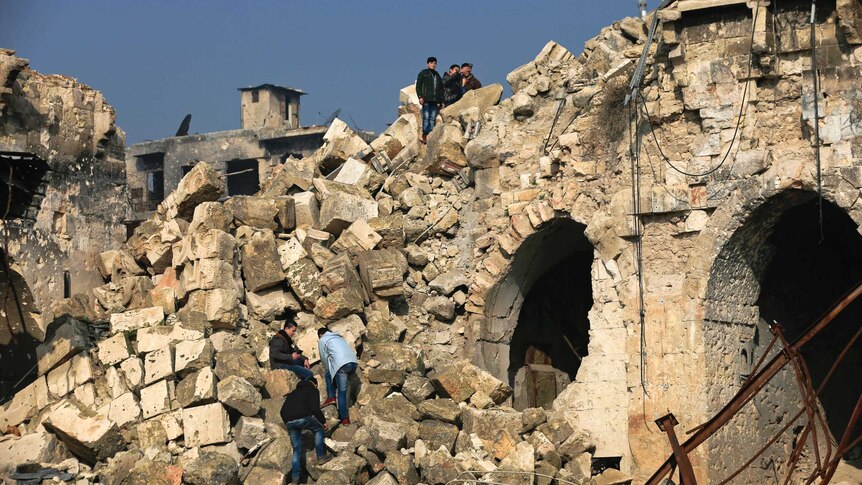 Youths climb on the rubble of the collapsed minaret at the heavily damaged Great Mosque of Aleppo.