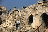 Youths climb on the rubble of the collapsed minaret at the heavily damaged Great Mosque of Aleppo.