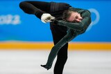 An ice skater spins, her foot behind her head.