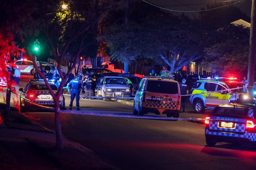 Police in a cordoned off area of a suburban street just after dusk