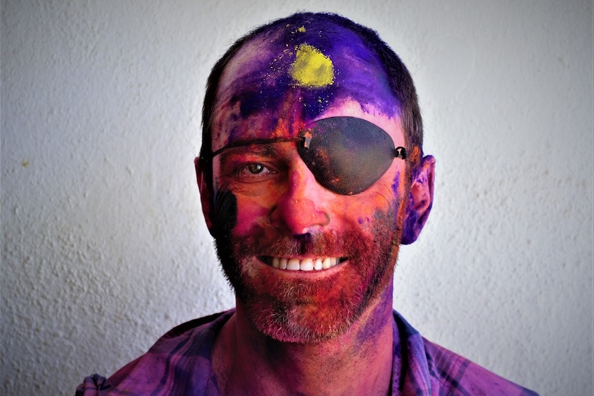 A picture of blind photographer Kristan Emerson, covered in colourful powder after attending the Holi Festival in India