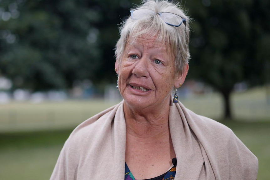 A woman in a park being interviewed for TV