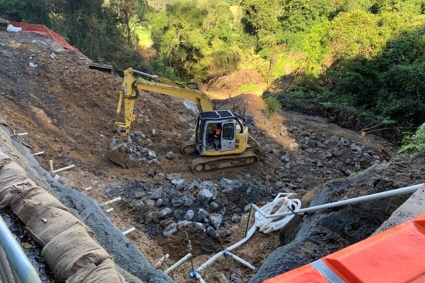 Una excavadora repara un deslizamiento de tierra masivo