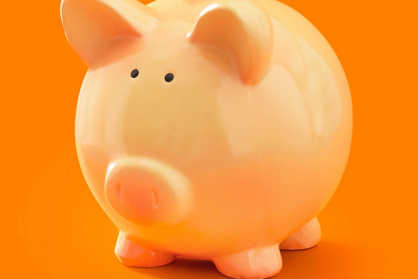 Piggy bank in front of orange background, illustrating our 7 money tips to help kick start your savings.