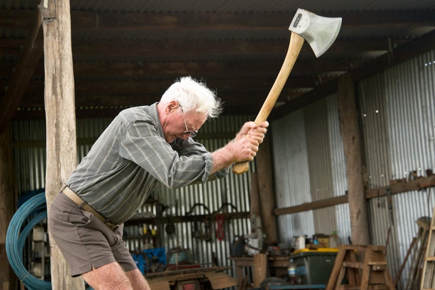 Martin Conole pulls his axe from a block of timber.