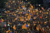 Thousands of people pack a street with independence flags on Catalan National Day.