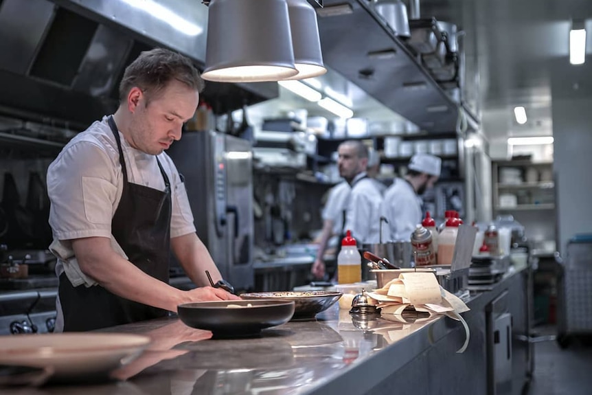 A chef prepares food in an industrial kitchen