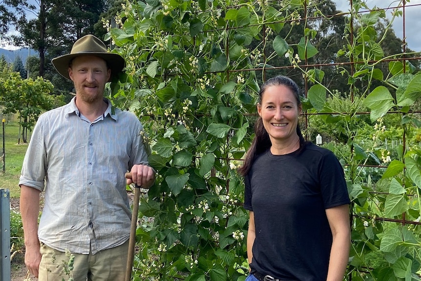 a man and a woman standing next to a health bean crop