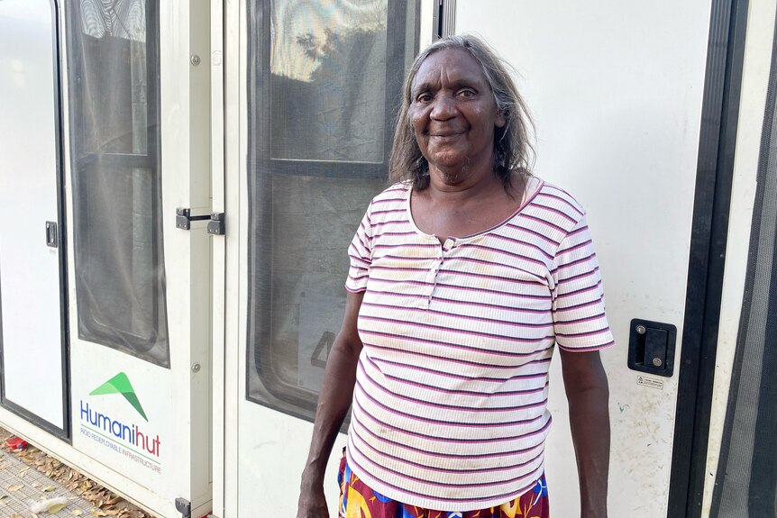 An aboriginal woman standing in front of a shipping container