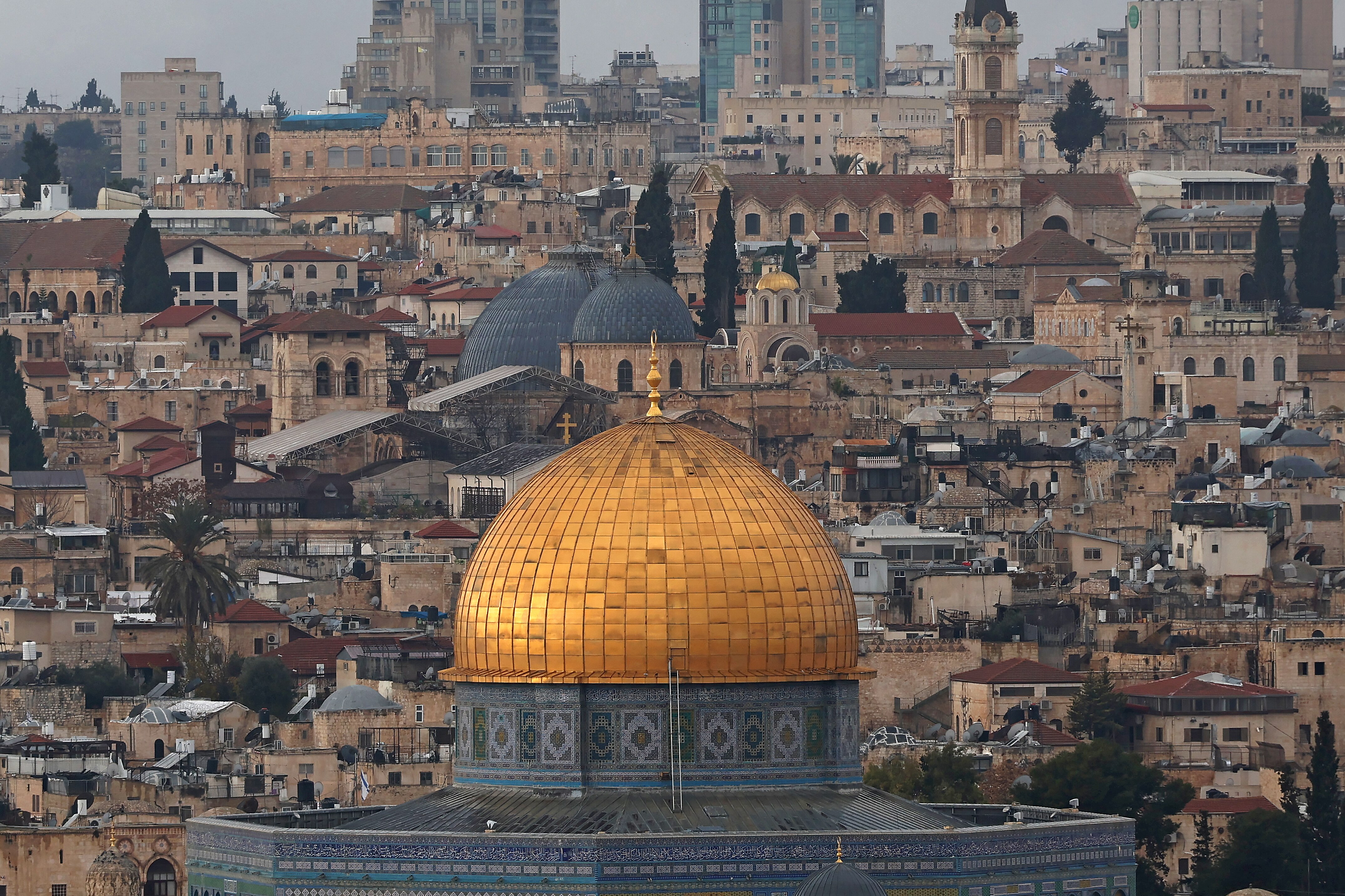 The golden dome of a mosque against the backdrop of a city