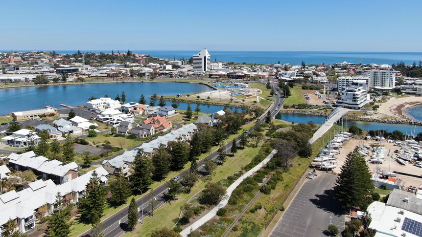 An aerial photo of parklands and an inlet leading into a town centre