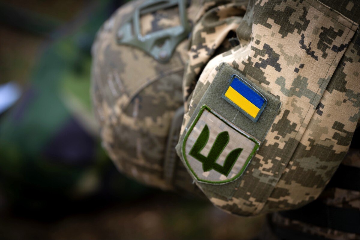 A soldier's shoulder, with a Ukrainian flag patch visible on it.