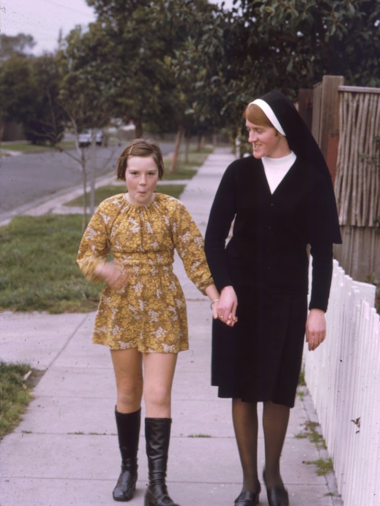 A photo of a nun holding hands with her little sister walking down the street in Melbourne in 1974.