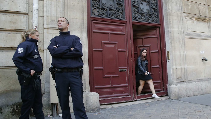 French police officers stand outside a building