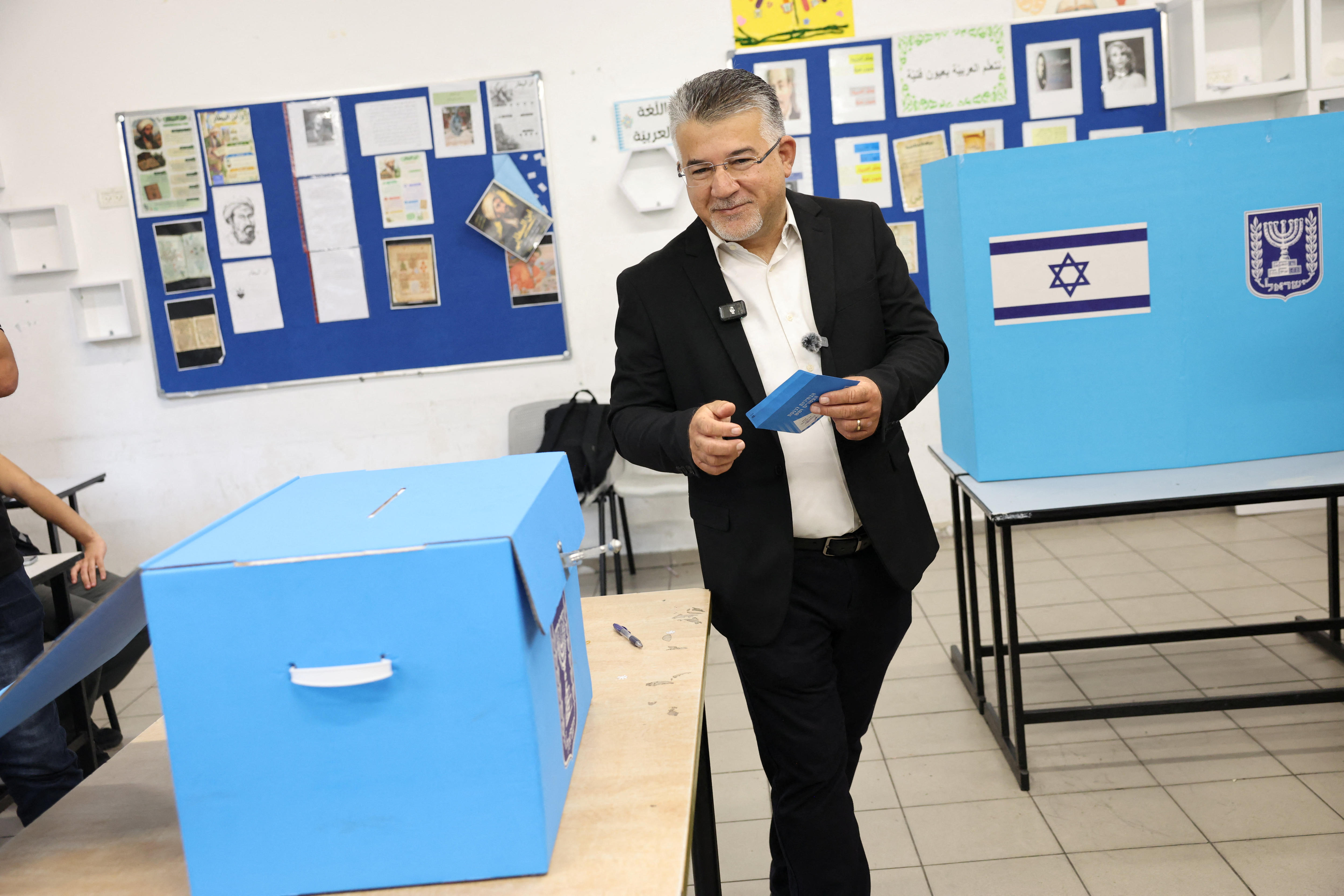 Yousef Jabareen walks beside a blue box with an envelope