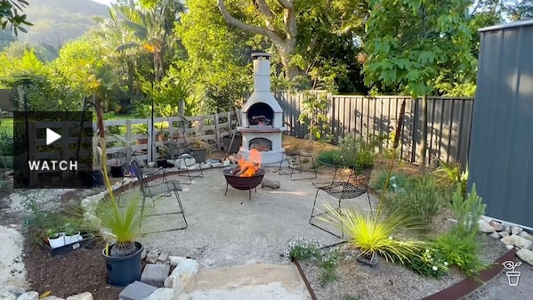 A seating circle in a garden with a chimnea fire. Has Video.