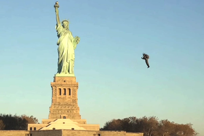 David Mayman flies around the Statue of Liberty wearing a jetpack.