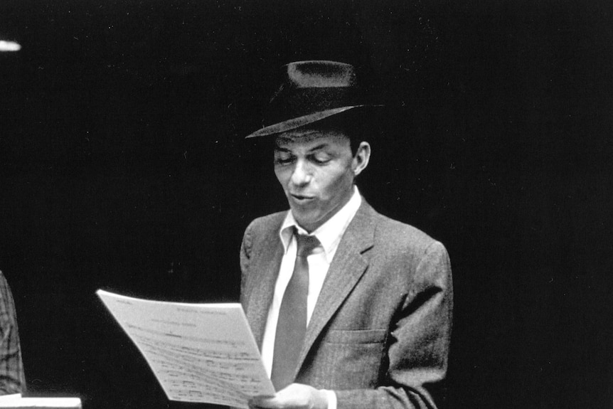 Frank Sinatra looks at some sheet music.