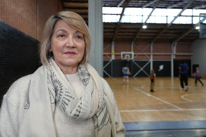 Barbara Erichsdotter stands with a basketball court in the background. Her expression is neutral. 