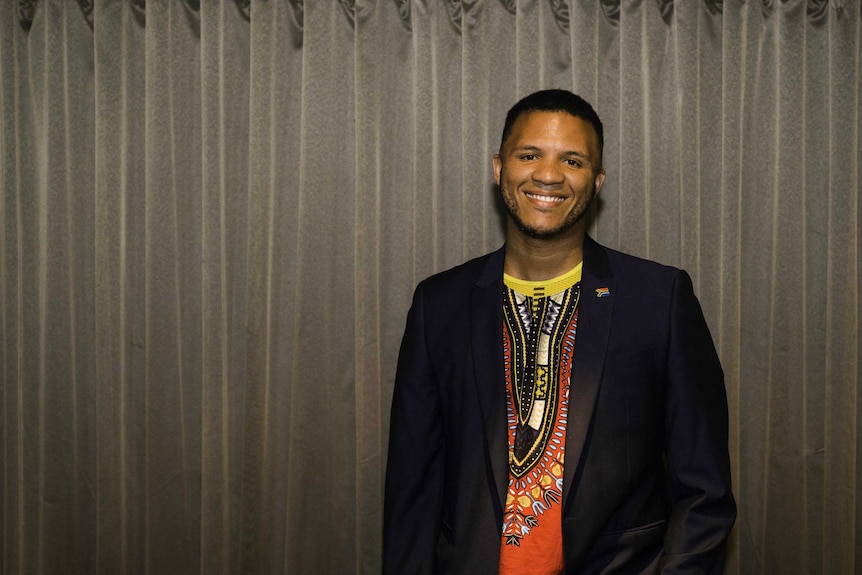 A young African man poses for a photo