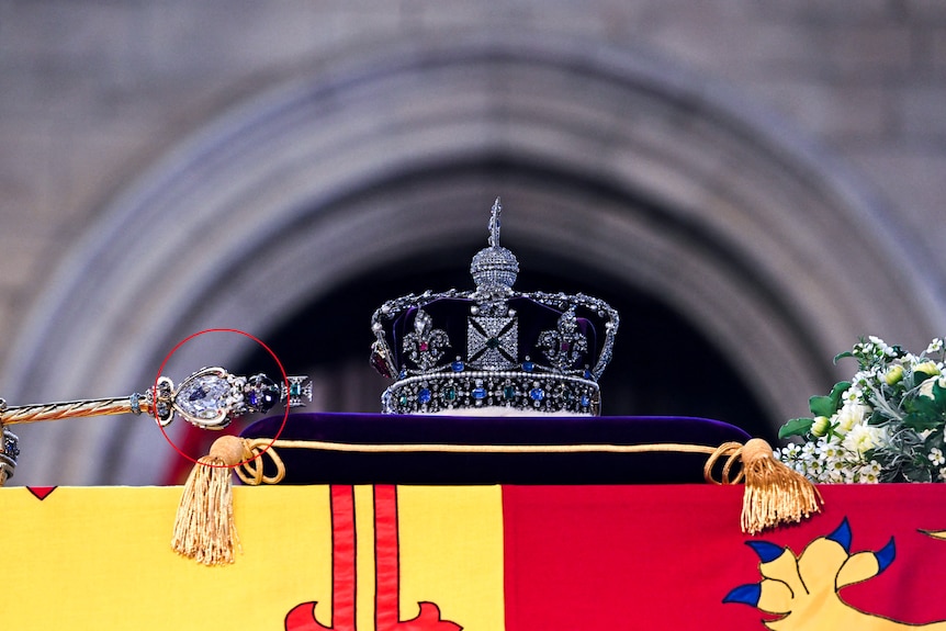 The royal sceptre lays face down on the Queen's coffin with a large diamond in the centre.