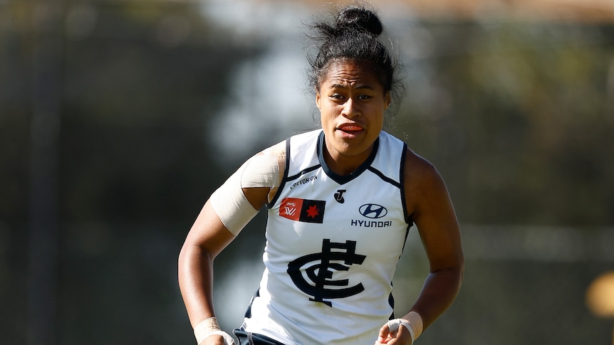 Mua Laloifi chases a ball for Carlton during an AFLW game.