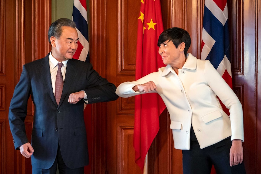 Wang Yi bumps elbows with Norway's foreign minister Ine Erisen Soreide in Oslo last month.