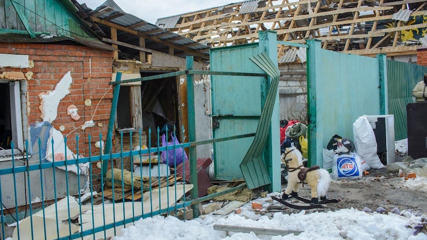 The remains of two houses with rubble on the street