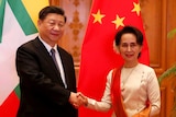 Myanmar State Counselor Aung San Suu Kyi, right, greets Chinese President Xi Jinping.