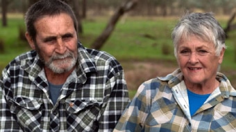 A couple wearing checked flannel shirts fill the frame