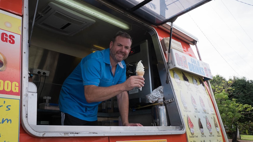 Man holding ice cream in van serving window