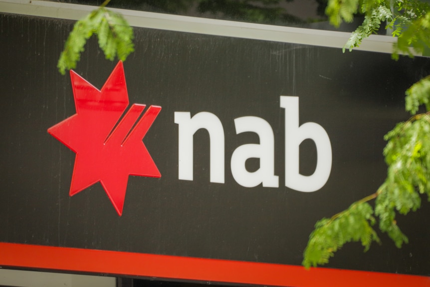 A NAB sign with a few jacaranda branches in front of it. 
