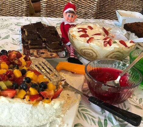An elf among trifle and chocolate desserts.