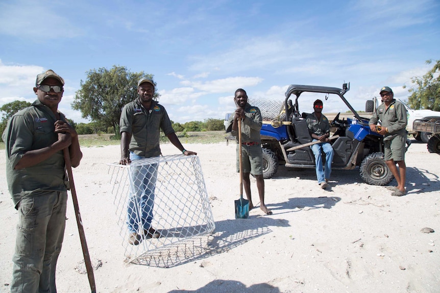 Five rangers on a Pormpuraaw beach with aluminium cage and atv