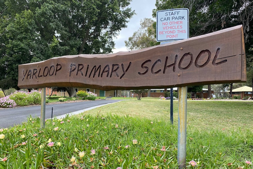 A wooden sign saying "Yarloop Primary School" outside the school grounds.