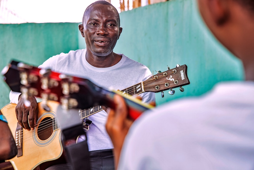 Victor Erebifa Phullu teaching guitar at his local church. 