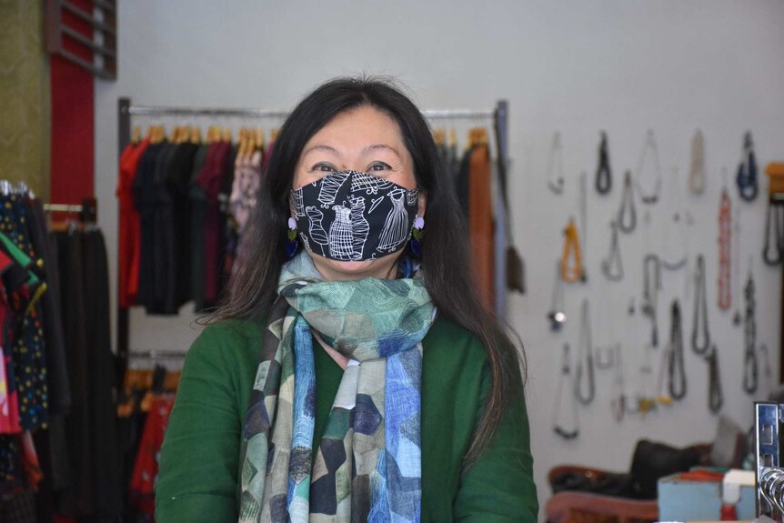 Eliza Lim wears a face mask as she poses for a photo in her clothing boutique.
