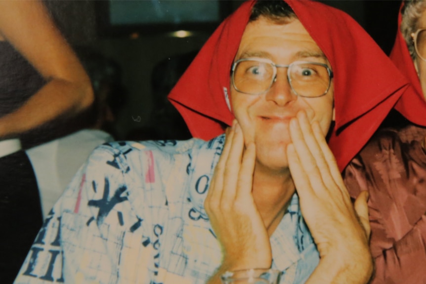 Bernard McGrath with a red sweater over his head