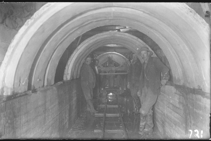 Workers pose in a Canberra sewerage tunnel.