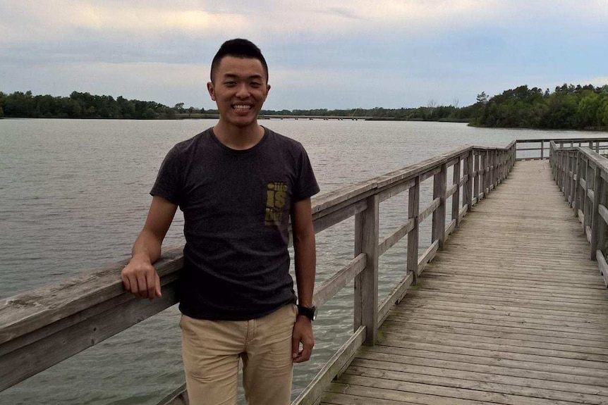 A man standing on a bridge.