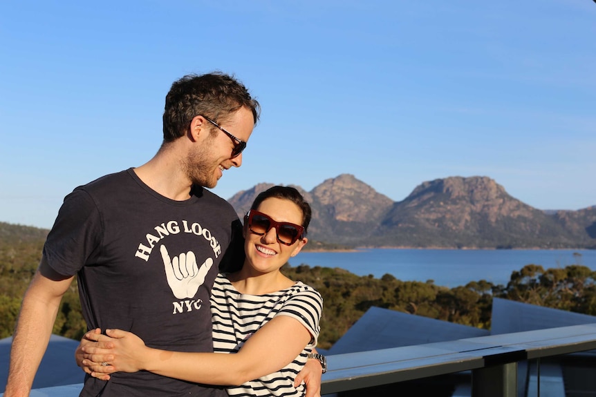 Hamish Blake smiles at his wife Zoe Foster-Blake who is smiling at the camera in front of some mountains