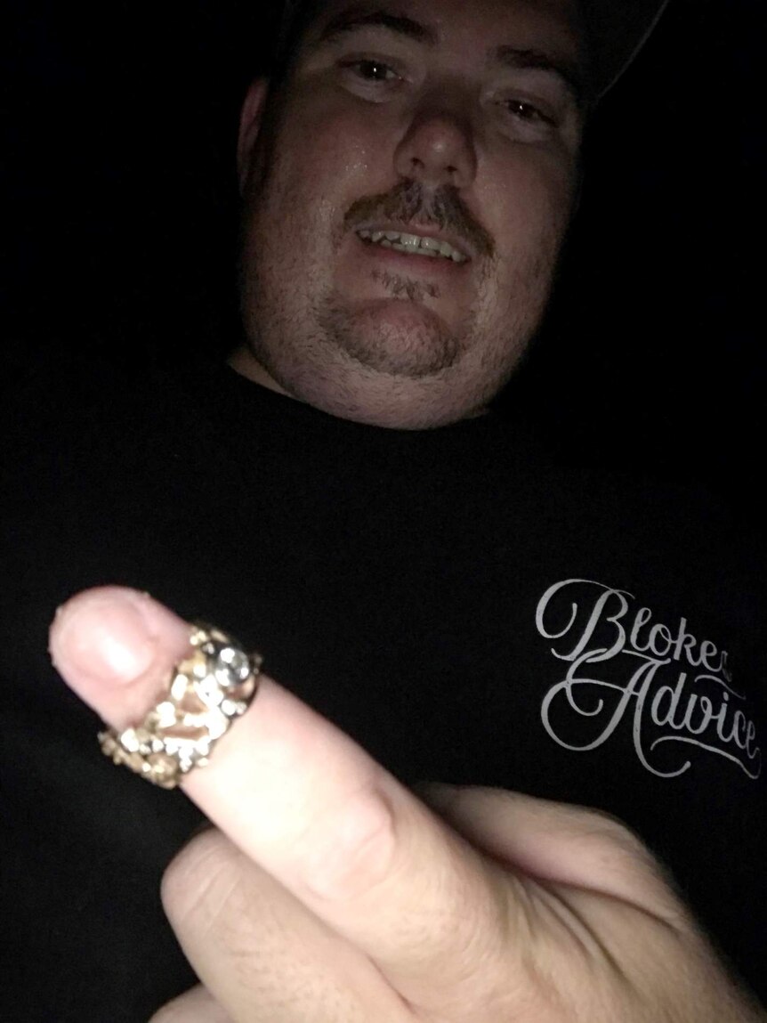 Selfie of man with ring on his finger